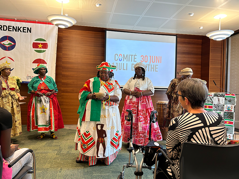 Jetta Klijnsma en 3 vrouwen staan naast een overdekte kar met het logo en webadres van het Leger des Heils