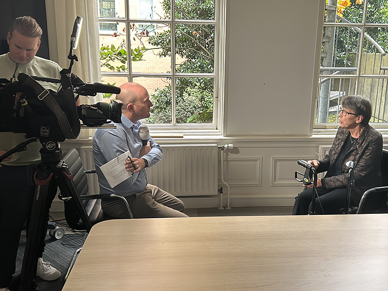 Jetta Klijnsma en 3 vrouwen staan naast een overdekte kar met het logo en webadres van het Leger des Heils