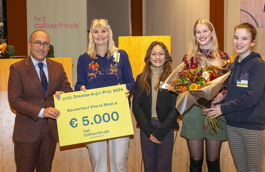 Dames van Koorschool Viva la Musica houden een cheque ter waarde van 5.000 euro in de hand
